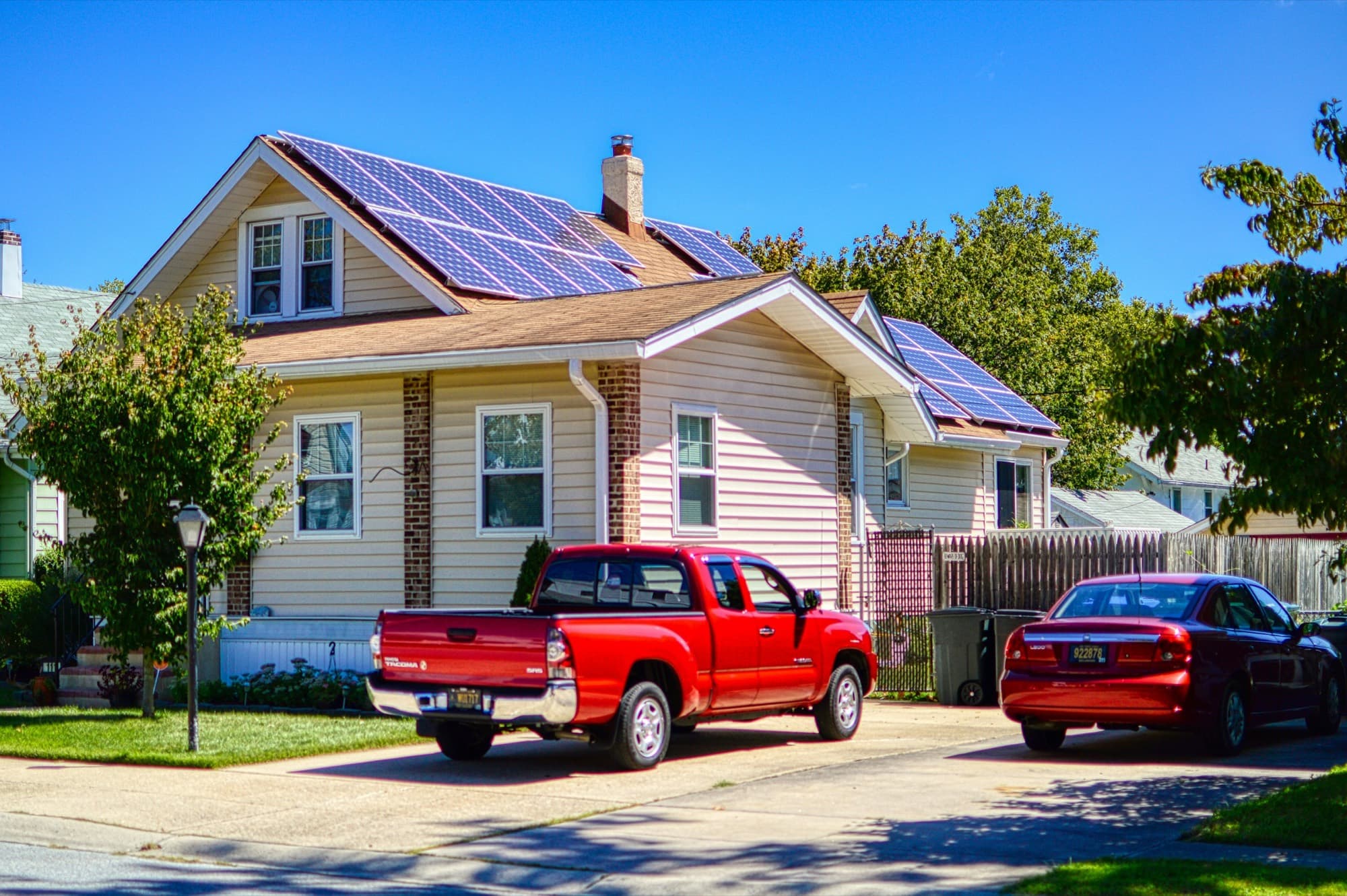 Suburban family home with rooftop solar and a pickup in the driveway